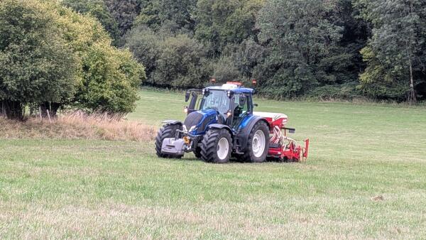 Tractor planting grass seed in a field
